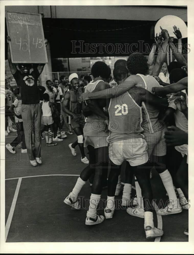 1984 Press Photo Central Village basketball players embrace after winning basket- Historic Images