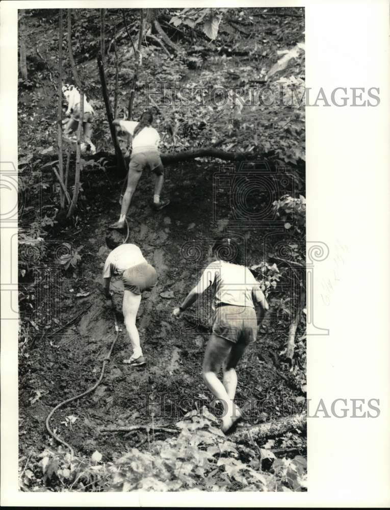 1987 Press Photo Runners scramble up the mud bank during Elbridge Alpine Classic- Historic Images