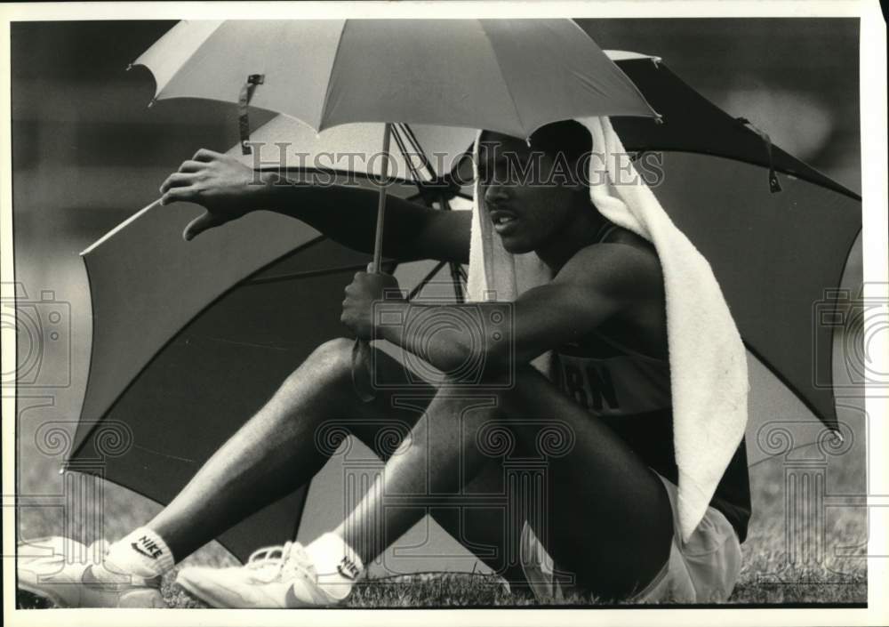 1988 Press Photo Western track athlete Lawrence Lewis holds umbrellas- Historic Images