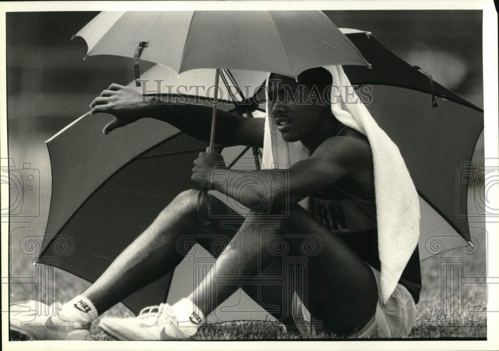 1988 Press Photo Western track athlete Lawrence Lewis holds umbrellas- Historic Images