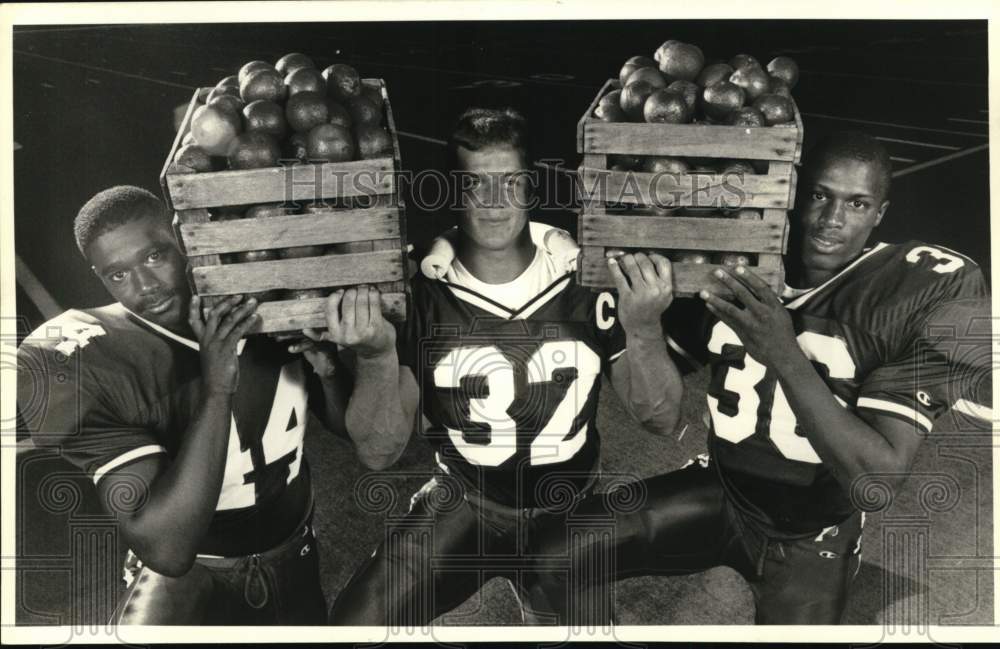 1988 Press Photo Syracuse U football running backs hold up crates of oranges- Historic Images