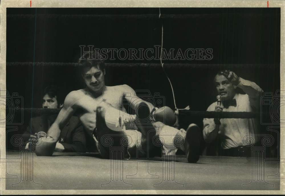 1986 Press Photo Boxer Chuck Binaxas falls backward to the mat in boxing ring- Historic Images