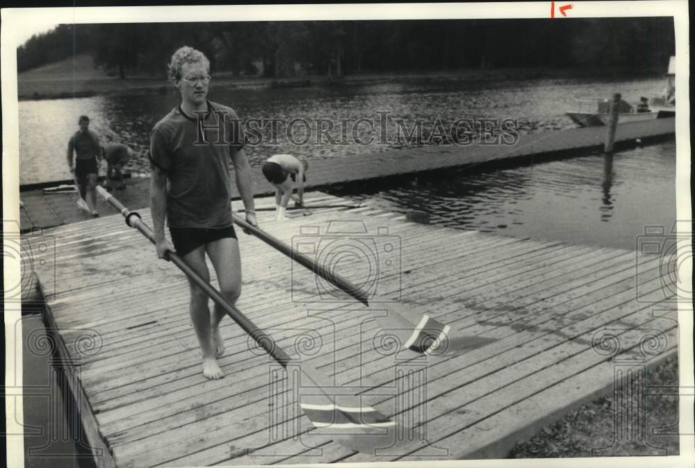 1985 Press Photo Syracuse University Varsity 8 Crew members carry oars from boat- Historic Images