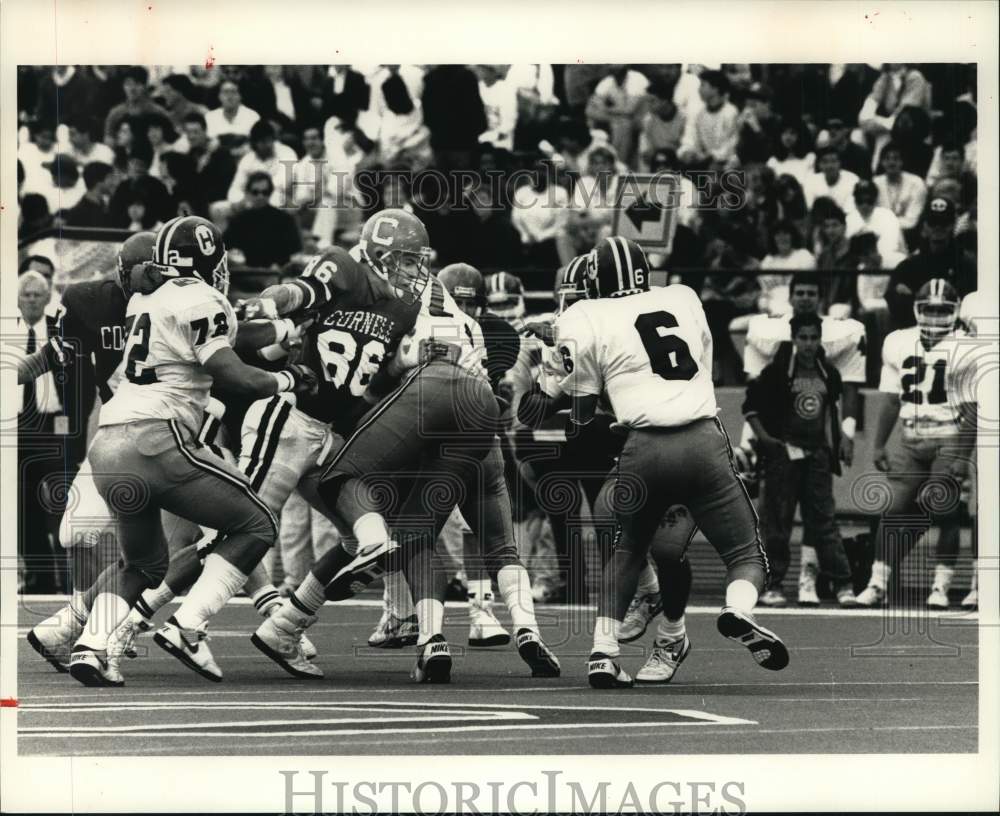 1989 Press Photo Cornell football player #86 battles Harvard players during game- Historic Images