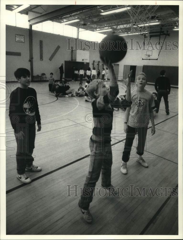 1988 Press Photo Chris Devendorf shoots basketball at Minoa Elementary School NY- Historic Images