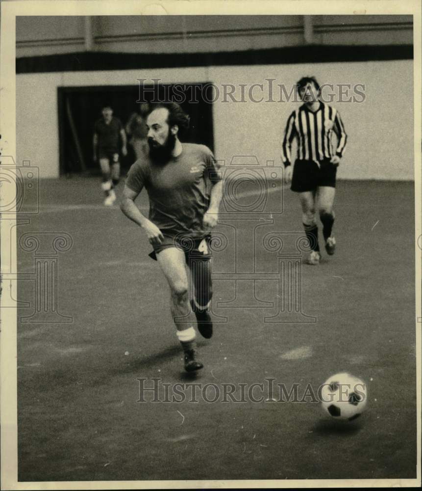 1984 Press Photo Soccer player chases down ball as referee follows behind him- Historic Images