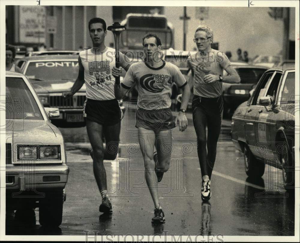 1986 Press Photo Runners Carry Empire State Games Torch on Washington Street- Historic Images
