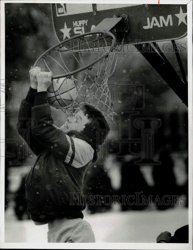 1987 Press Photo Aaron Acome hangs onto basketball hoop at his home in Fulton.- Historic Images