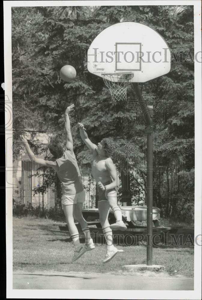 1986 Press Photo Joel Serafin and Aron Backus play basketball on backyard court.- Historic Images