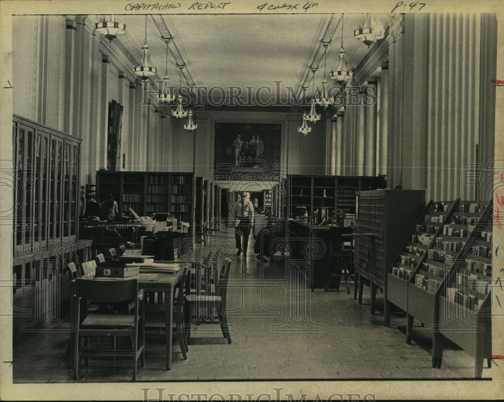 Press Photo Man walks past shelves of books in New York State Library