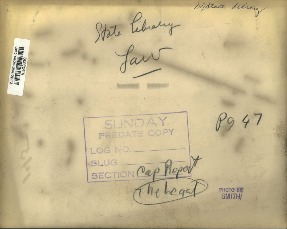 Press Photo Man walks past shelves of books in New York State Library