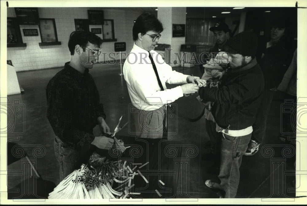 1991 Press Photo Men give arm bands, Grateful Dead Concert Knickerbocker Arena- Historic Images