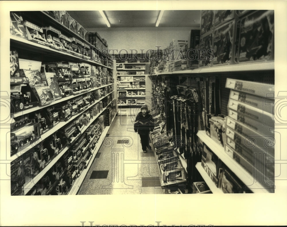 Press Photo Balston Lake, New York toddler walks down toy aisle in store- Historic Images