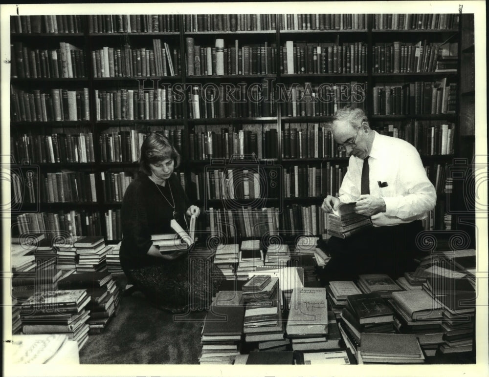1990 Press Photo Mr. & Mr.s Whitburn sort books in their Ballston Lake, NY home- Historic Images