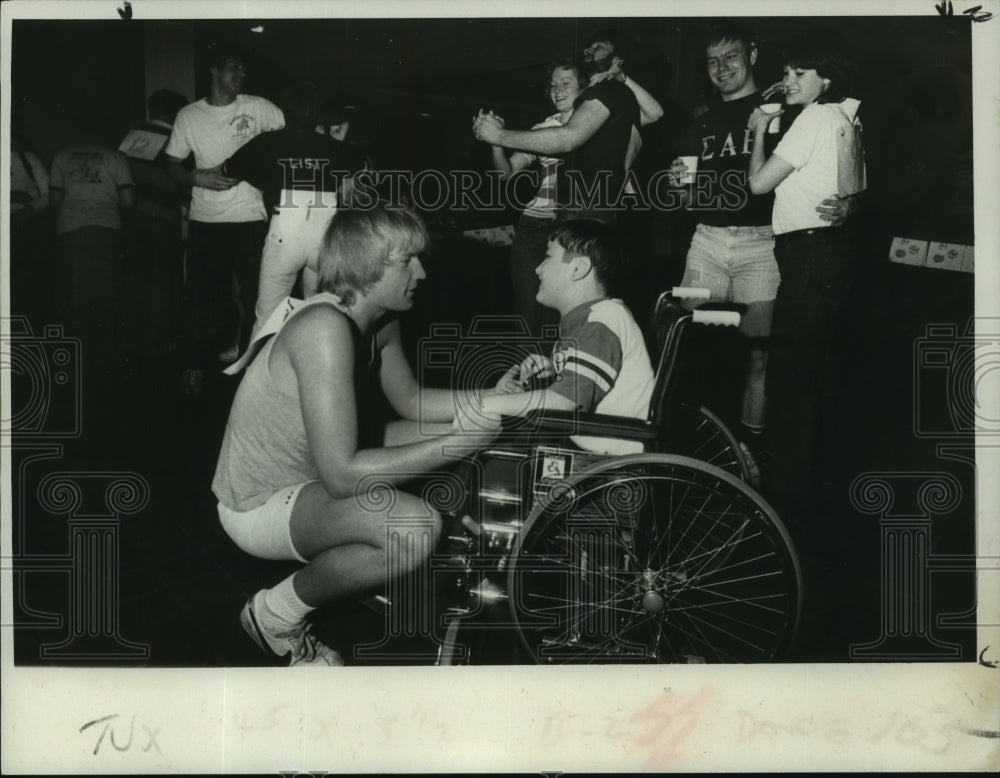 1980 Press Photo College freshman dances with kid in wheelchair in Troy, NY- Historic Images