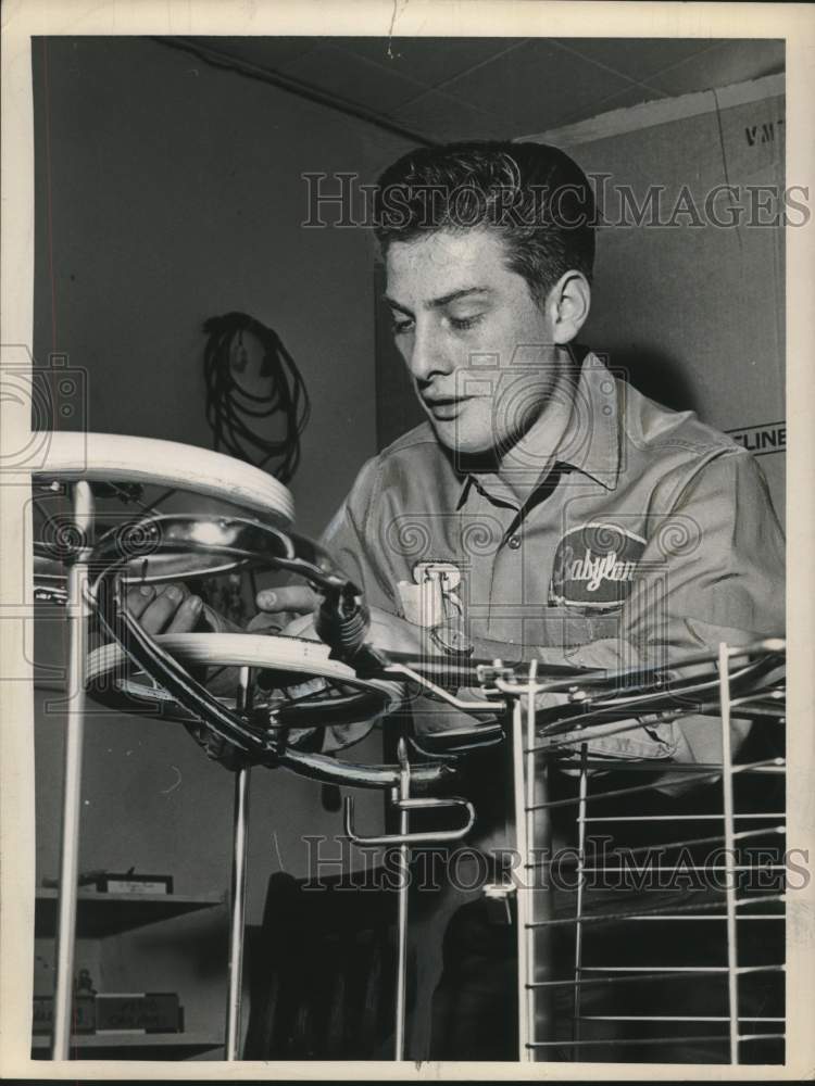 1965 Press Photo School dropouts.Unnamed young man working on baby stroller- Historic Images