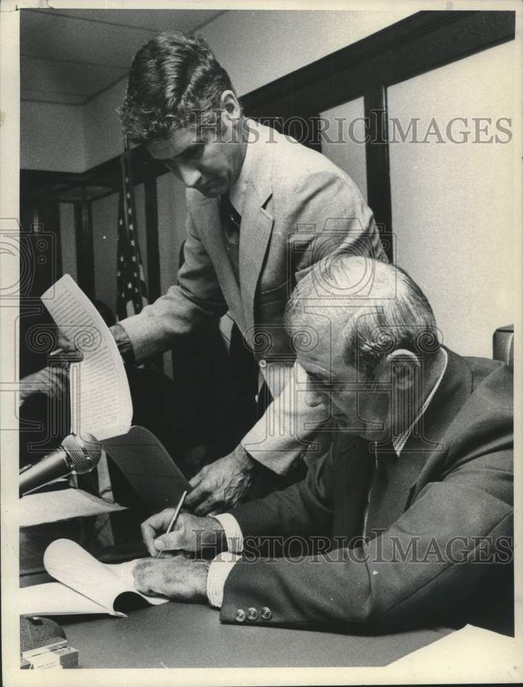 1975 Press Photo J. Leo O'Brien signs police contract as Joseph Minaghan watches