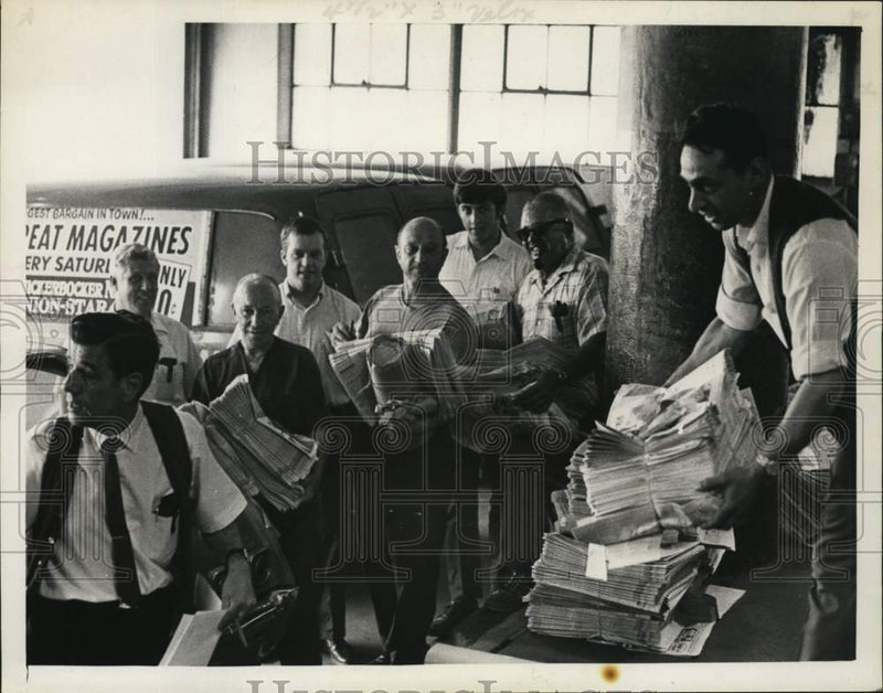 Load image into Gallery viewer, 1969 Press Photo Julius Padula hands out bundles of newspapers to men lined up
