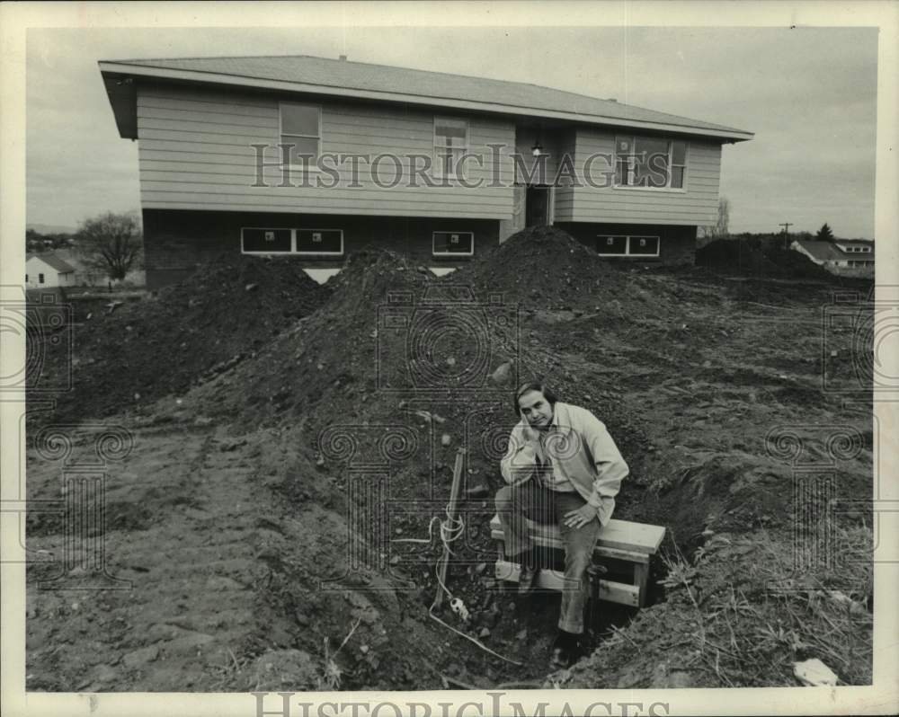 1973 Press Photo Al Hanley sits by water valve in front of his new home