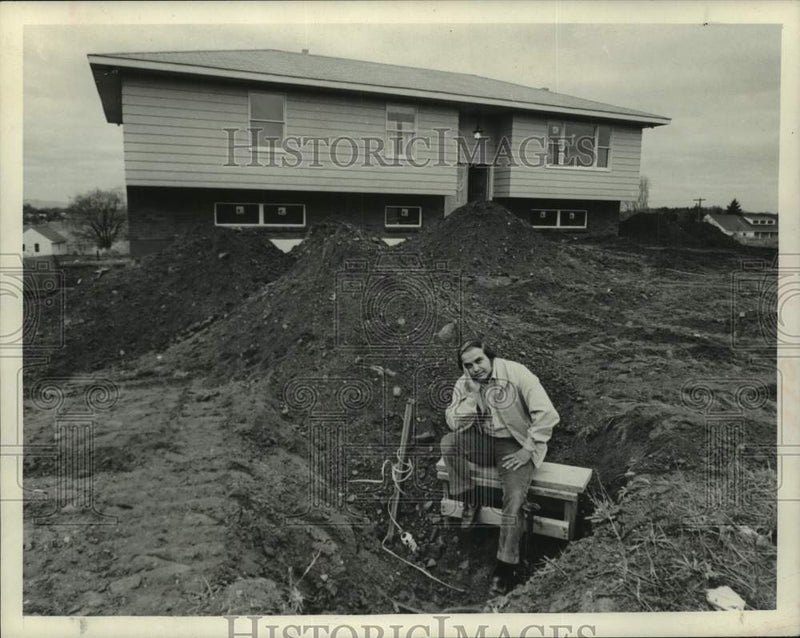 Load image into Gallery viewer, 1973 Press Photo Al Hanley sits by water valve in front of his new home
