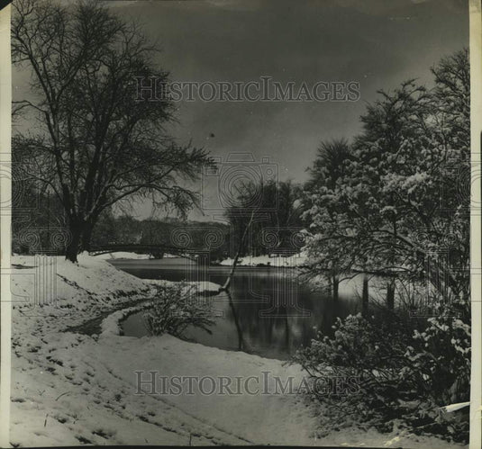 1961 Press Photo View down river, bridge in background as snow covers grounds