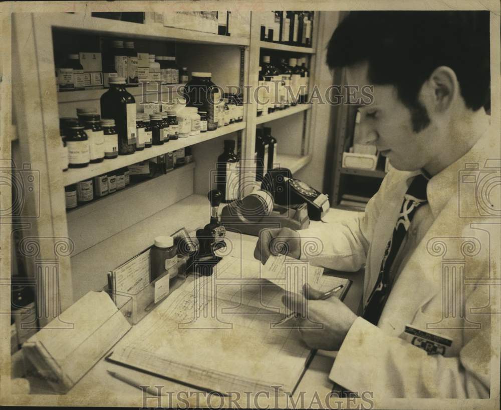 1973 Press Photo Pharmacist Frank Dosennia looks at prescription at St Peter's