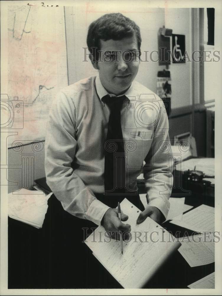 Load image into Gallery viewer, 1974 Press Photo Dennis O'Malley sits on his desk with pad of paper and pen
