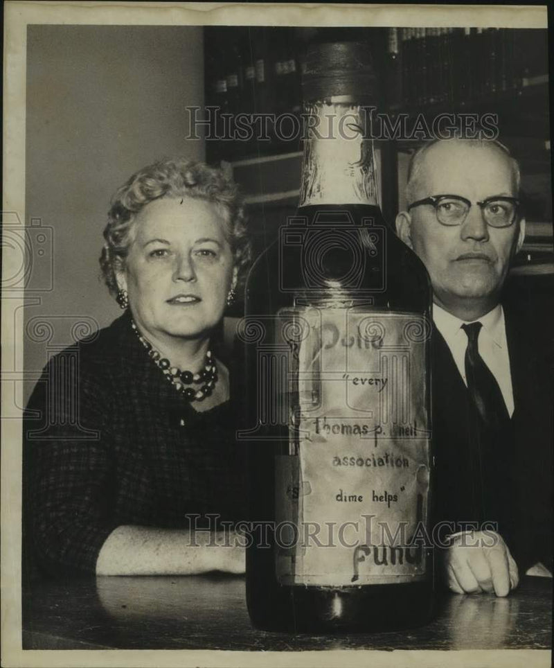 Load image into Gallery viewer, 1961 Press Photo Mrs Gerald O'Neil presents bottle of contribution for charity
