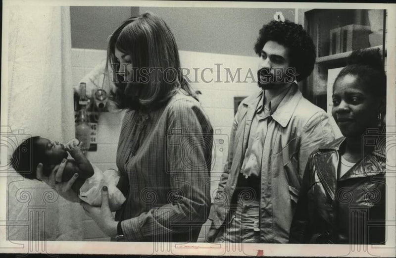 Load image into Gallery viewer, 1980 Press Photo Mr &amp; Mrs Steven King watch RN check on their baby at St Mary's
