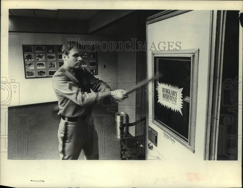 Load image into Gallery viewer, 1977 Press Photo New York police officer swings bat at glass panel in Albany
