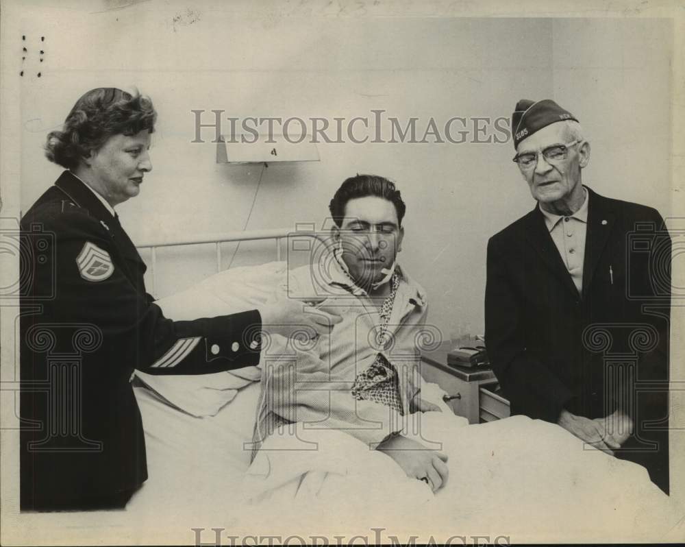 1965 Press Photo Man in Albany, New York hospital records message for troops