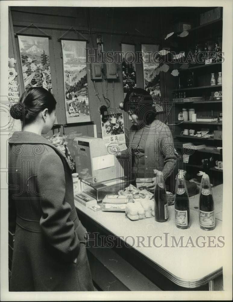 1977 Press Photo Clerk rings up customer at Asian food store in New York