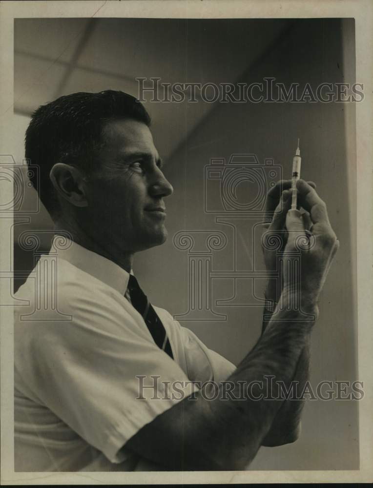 1968 Press Photo Dr. Roy D. Shaffer inspects syringe in Albany, New York