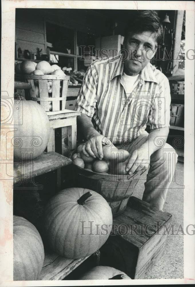 Load image into Gallery viewer, 1980 Press Photo Jimmy Monalo stands next to produce at Valley Acres Farm
