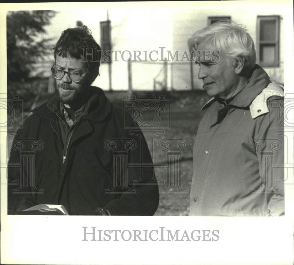 1990 Press Photo Men look over book in Troy, New York - tua29623- Historic Images