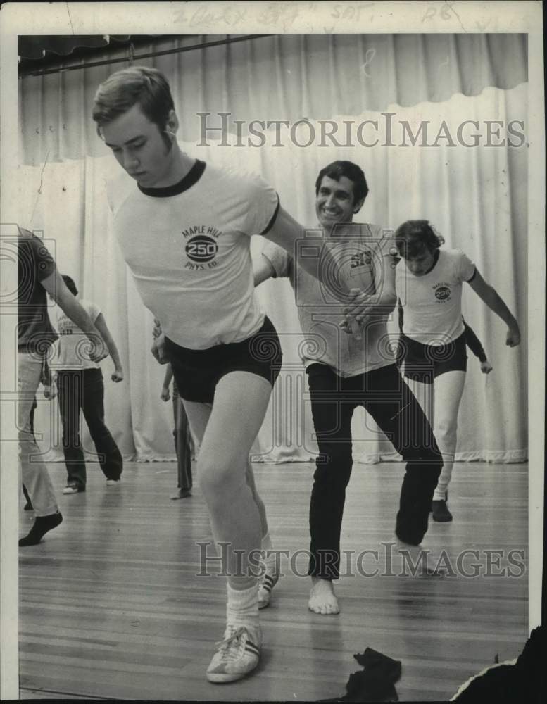 1971 Press Photo Tony Montanaro helps Bill Farei stretch in Schodack, New York- Historic Images