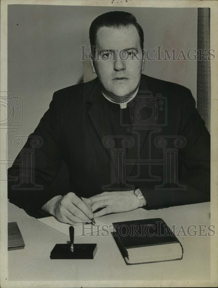 Load image into Gallery viewer, 1966 Press Photo Reverend Thomas J Maloney sits behind desk writing letter
