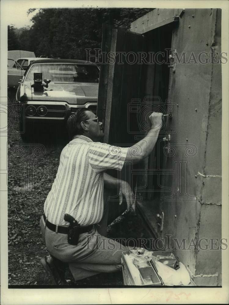 1975 Press Photo New York State Police investigator looks at dynamite locker