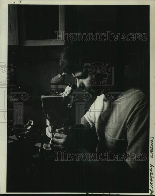 1975 Press Photo Don Malloy looks through microscope to study black flies.