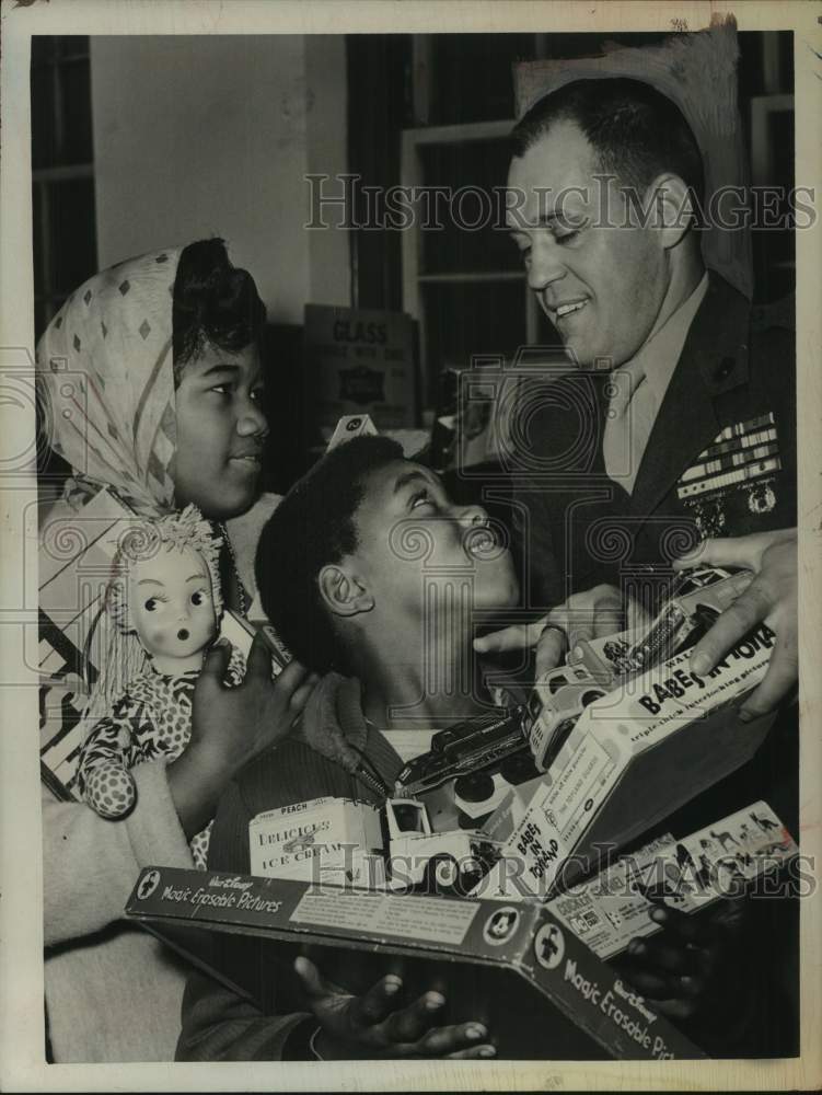 1961 Press Photo US Marine Reservist delivers donated toys to Albany, NY child