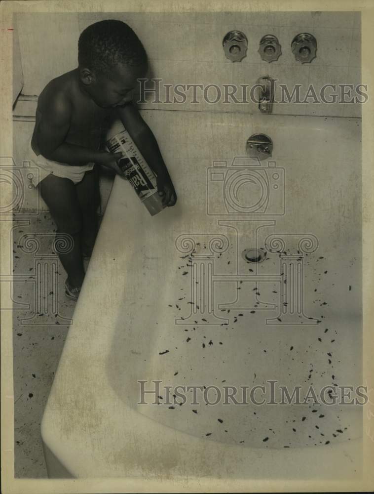Load image into Gallery viewer, 1968 Press Photo Bobby Trotter sprays Raid on roaches covering bathtub &amp; floor

