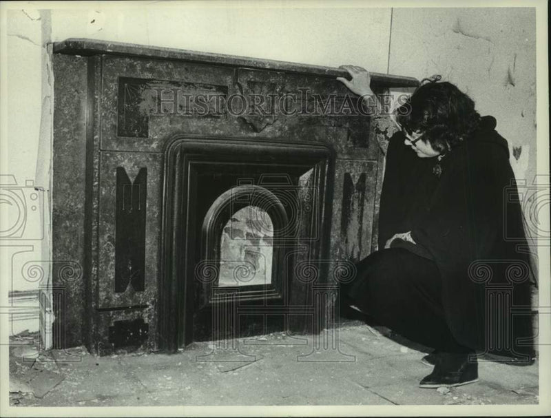 Load image into Gallery viewer, 1977 Press Photo Barbara Martin looks at fireplace in distressed building
