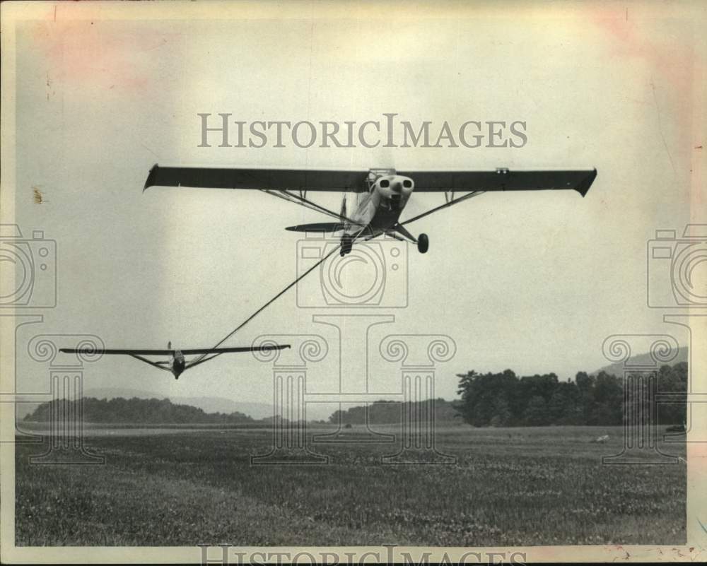 1973 Press Photo Plane takes off from grass runway with a glader tethered to it