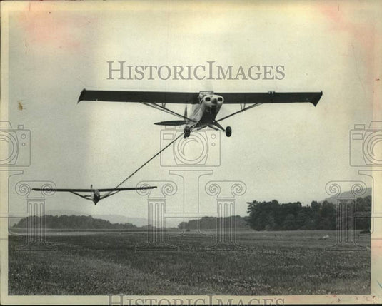 1973 Press Photo Plane takes off from grass runway with a glader tethered to it