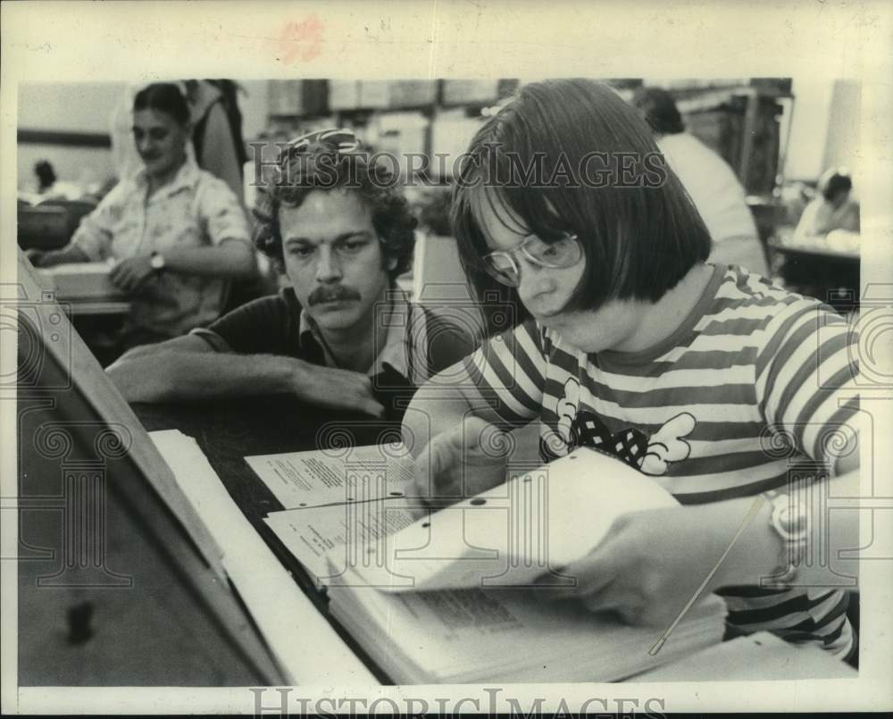 1978 Press Photo Bruce Lawrence helps Dorina Sicley update law books in New York- Historic Images