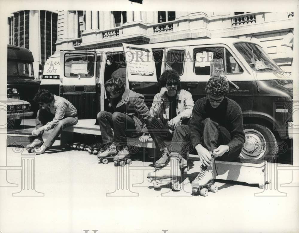 1980 Press Photo Group laces up roller skates on State Street, Albany, New York- Historic Images