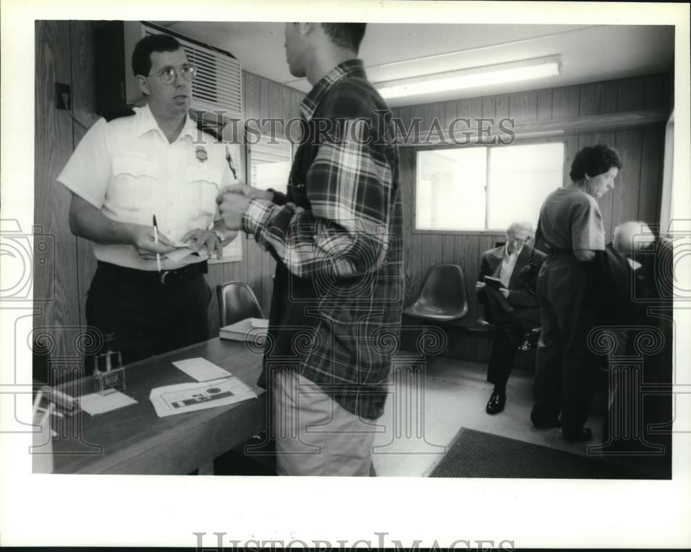 1994 Press Photo Inspector checks traveler&#39;s passport at airport in New York