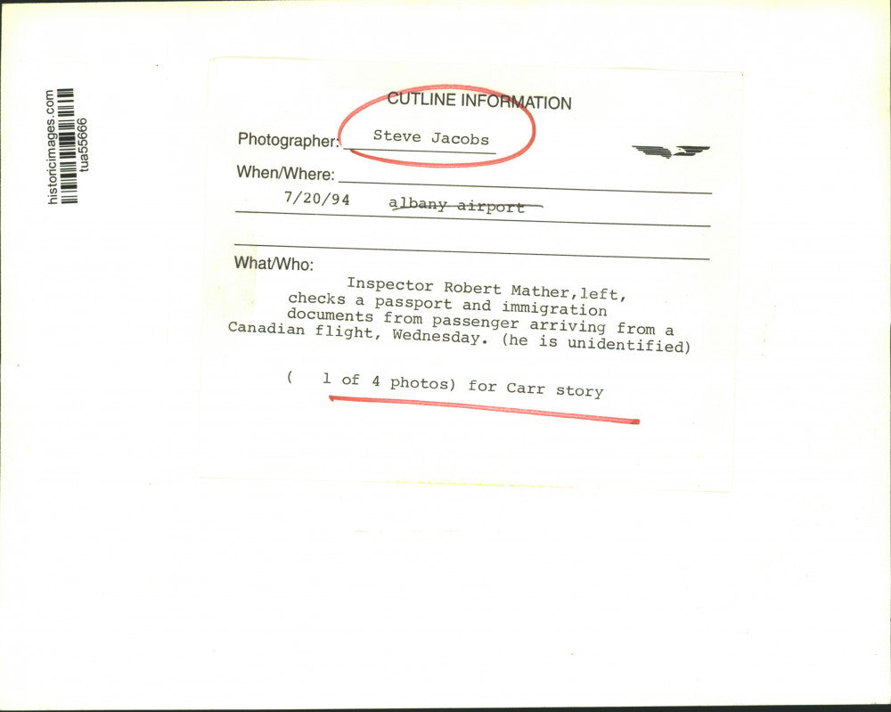 1994 Press Photo Inspector checks traveler's passport at airport in New York