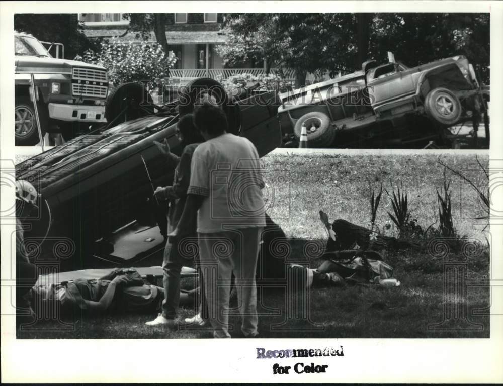 1992 Press Photo Rescuers tend to driver of overturned car in Albany, New York