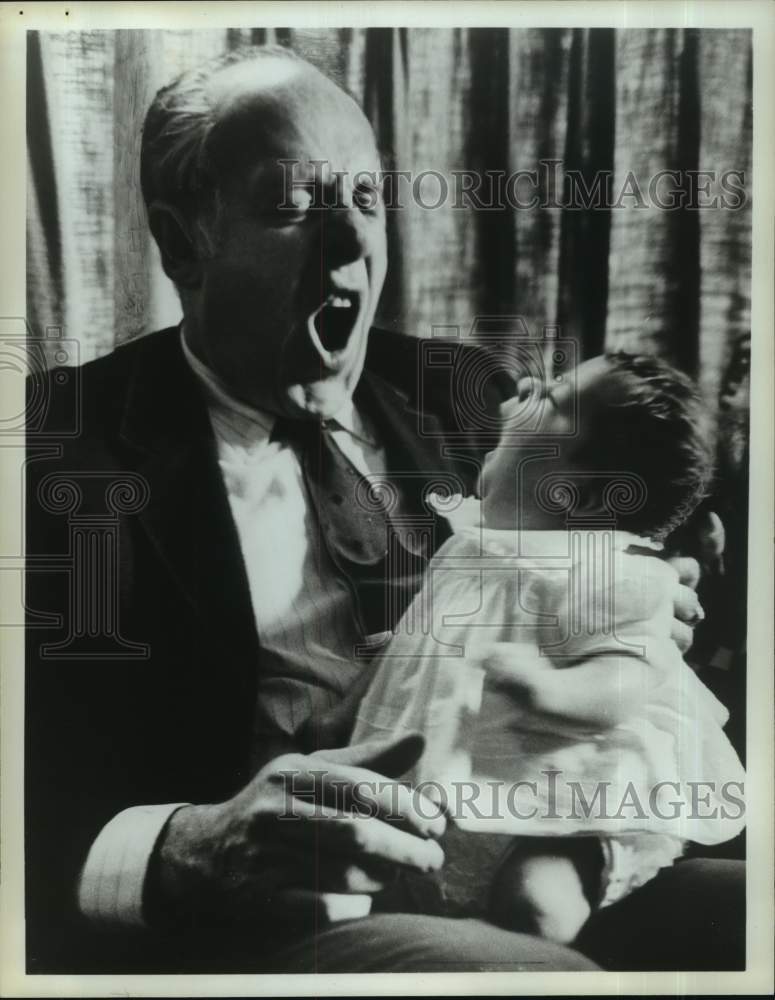 Press Photo Basketball coach Red Auerbach mocks baby in his lap - tua59457- Historic Images
